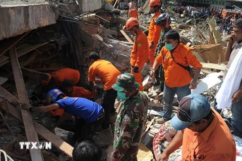 Lực lượng cứu hộ Indonesia tìm kiếm các nạn nhân còn mắc kẹt trong đống đổ nát sau trận động đất tại tỉnh Aceh ngày 7/12. (Nguồn: AFP/TTXVN)