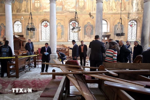 Nhân viên an ninh và người dân điều tra tại hiện trường nhà thờ Công giáo Coptic ở quận Abbasiya sau vụ đánh bom. (Nguồn: EPA/TTXVN)