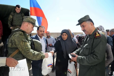 Người dân Syria nhận hàng cứu trợ của Nga tại khu vực ngoại ô thủ đô Damascus ngày 24/11. (Nguồn: EPA/TTXVN)