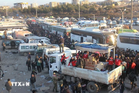 Các thành viên Cơ quan dân sự Syria phân phát hàng cứu trợ cho những người dân tại Khan al-Assal, phía tây Aleppo ngày 19/12. (Nguồn: AP/TTXVN)