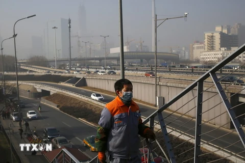 Người dân đeo khẩu trang tránh ô nhiễmkhông khí ở thủ đô Bắc Kinh ngày 2/1. (Nguồn: EPA/TTXVN)