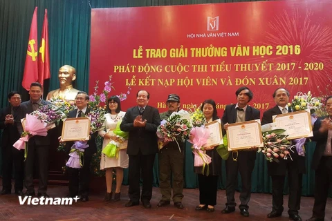Nhà thơ Nguyễn Việt Chiến nhận giải thưởng Hội nhà văn. (Ảnh: Mỹ Bình/Vietnam+)