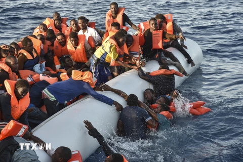 Đội cứu hộ và Hội Chữ thập Đỏ Italy cứu giúp người di cư sau khi thuyền của họ bị chìm ngoài khơi Libya ngày 3/11/2016. (Nguồn: AFP/TTXVN)