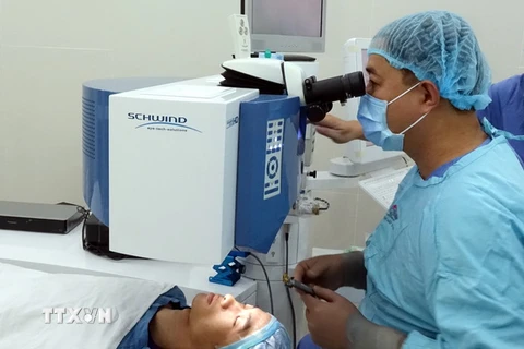 Bác sỹ Bệnh viện Mắt Thành phố Hồ Chí Minh thực hiện ca phẫu thuật khúc xạ mắt bằng Laser công nghệ SmartSurfACE cho bệnh nhân. (Ảnh: Phương Vy/TTXVN)