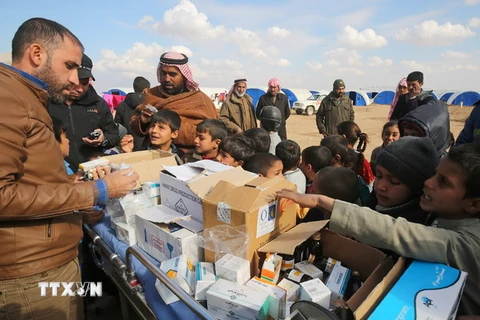 Nhân viên y tế Iraq phát thuốc cho trẻ em ở trại tị nạn Al-Agha gần làng Tal Afar, tây nam Mosul ngày 16/2. (Nguồn: AFP/TTXVN)