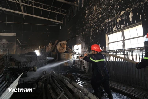 Lực lượng cứu hỏa tham gia dập lửa. (Ảnh: Huyền Trang/Vietnam+)