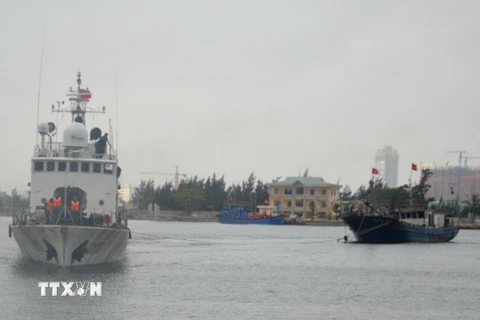 Tàu Cảnh sát biển 2016 lai dắt tàu cá bị nạn về đất liền. (Ảnh: Đinh Văn Nhiều/TTXVN)