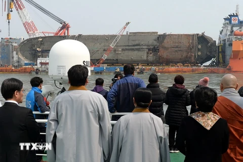 Thân nhân các nạn nhân trong vụ chìm phà Sewol theo dõi quá trình trục vớt ở ngoài khơi đảo Jindo, Hàn Quốc ngày 28/3. (Nguồn: EPA/TTXVN)