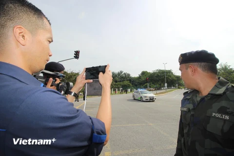 Xe cảnh sát dẫn đầu đoàn xe chở các nghi phạm rời tòa án. (Ảnh: Hoàng Nhương/Vietnam+)