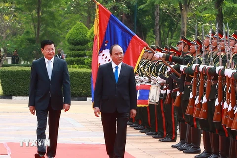 Thủ tướng Nguyễn Xuân Phúc và Thủ tướng Lào Thongloun Sisoulith duyệt Đội danh dự. (Ảnh: Thống Nhất/TTXVN)