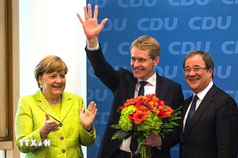 Thủ tướng Đức Angela Merkel (trái) , ứng cử viên trong cuộc bầu cử Nghị viện bang Schleswig-Holstein của đảng CDU Daniel Guenther (giữa) mừng chiến thắng tại Berlin ngày 8/5. (Nguồn: AFP/TTXVN)