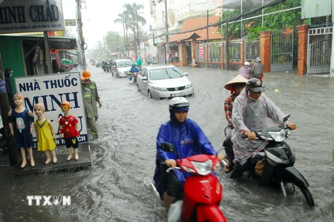 Mưa ngập đường Phan Huy Ích (thuộc quận Tân Bình và Gò Vấp) khiến giao thông ngặp nhiều khó khăn, hàng trăm phương tiện bị chết máy. (Ảnh: Mạnh Linh/TTXVN)