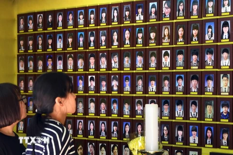 Du khách cầu nguyện trước di ảnh các nạn nhân trong vụ chìm phà Sewol ở Seoul ngày 25/5. (Nguồn: AFP/TTXVN)