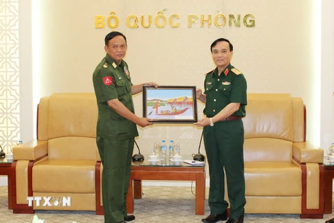 Trung tướng Phạm Hồng Hương và Thiếu tướng Thaw Lwin trao đổi tặng phẩm. (Ảnh: Hồng Pha/TTXVN phát)