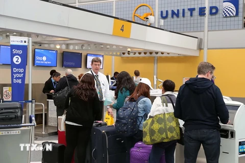 Hành khách làm thủ tục tại quầy của United Airlines ở sân bay Chicago, bang Illinois. (Nguồn: THX/TTXVN)