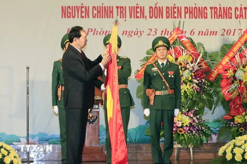 Chủ tịch nước Trần Đại Quang gắn Huy hiệu Anh hùng Lực lượng vũ trang nhân dân lên Cờ truyền thống của Bộ đội Biên phòng thành phố Hải Phòng. (Ảnh: Nhan Sáng/TTXVN)