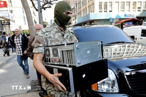 Lực lượng an ninh Liban trong chiến dịch đột kích các cửa hàng chuyển tiền và thu đổi ngoại tệ tại thủ đô Beirut ngày 8/3. (Nguồn: AFP/TTXVN)