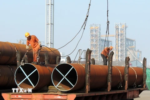 Công nhân vận chuyển thép tại một cảng ở thành phố Liên vận cảng, tỉnh Giang Tô, Trung Quốc. (Nguồn: AFP/TTXVN)