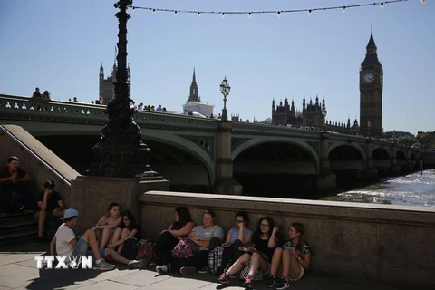 Người dân Anh nghỉ ngơi bên bờ Sông Thames ở trung tâm thành phố London. (Nguồn: AFP/TTXVN)