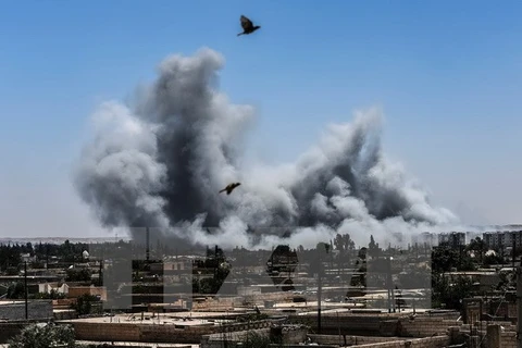 Khói bốc lên sau một cuộc không kích ở Raqqa, Syria ngày 15/7. (Nguồn: AFP/TTXVN)