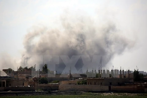 Khói bốc lên sau cuộc giao tranh ở quận al-Sinaa, phía Đông thành phố Raqqa ngày 21/6. (Nguồn: AFP/TTXVN)