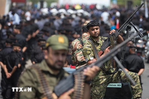 Các tay súng Palestine trung thành với phong trào Hồi giáo Hamas trong cuộc diễu binh tại thành phố Gaza ngày 26/7. (Nguồn: AFP/TTXVN)