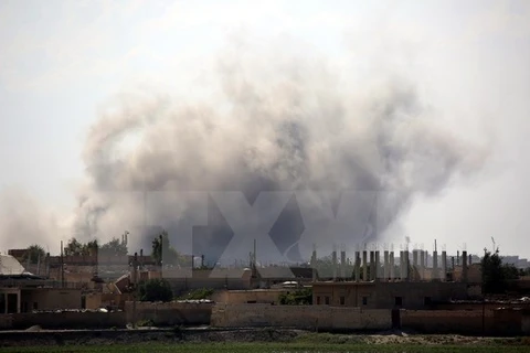 Khói bốc lên sau cuộc giao tranh ở quận al-Sinaa, phía Đông thành phố Raqa ngày 21/6. (Nguồn: AFP/TTXVN)