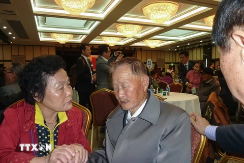 Bà Sun Kum-Soon (trái), 75 tuổi, người Hàn Quốc đoàn tụ với anh họ là Sun Yong-Ju (giữa), 82 tuổi, trong cuộc đoàn tụ ở Kumgang ngày 22/10. (Nguồn: AFP/TTXVN)
