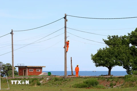 Sửa chữa lưới điện hạ thế trên đảo Cồn Cỏ. (Ảnh: Ngọc Hà/TTXVN)