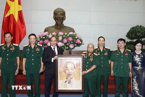 Thủ tướng Nguyễn Xuân Phúc tặng bức ảnh chân dung Chủ tịch Hồ Chí Minh cho Hội truyền thống Trường Sơn - đường Hồ Chí Minh. (Ảnh: Thống Nhất/TTXVN)