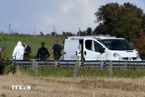 Cảnh sát điều tra chiếc xe ôtô BMW bị hư hỏng sau khi cảnh sát bắt giữ môt nghi phạm trên đường cao tốc A16, gần Marquise ngày 9/8. (Nguồn: AFP/TTXVN)