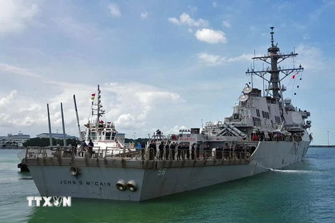 Tàu khu trục USS John S McCain được lai dắt tới căn cứ hải quân Changi ở ngoài khơi bờ biển phía đông Singapore sau vụ va chạm ngày 21/8. (Nguồn: EPA/TTXVN)