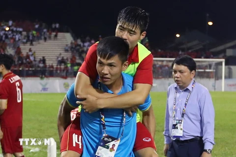 Cầu thủ Duy Mạnh bị chấn thương phải cần đến sự chăm sóc của bác sĩ sau trận đấu. (Ảnh: Quốc Khánh/TTXVN)