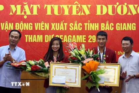 Phó Chủ tịch UBND tỉnh Bắc Giang Lê Ánh Dương (bên phải) khen thưởng cho các vận động viên. (Ảnh: Đồng Thúy/TTXVN)