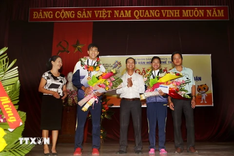 Đại diện lãnh đạo tỉnh Thừa Thiên-Huế, nhà trường và bạn vè chúc mừng vận động viên Trần Thị Yến Hoa và Lê Minh Thuận. (Ảnh: Hồ Cầu/TTXVN)
