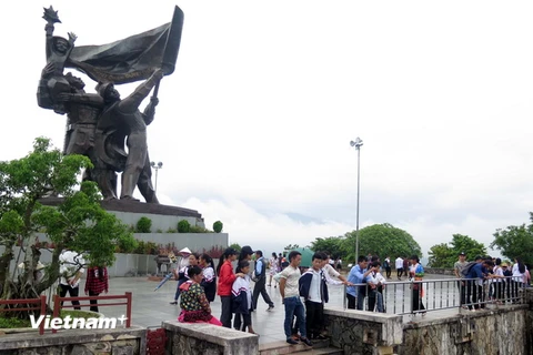 Người Mông lên tượng đài Chiến thắng trên đồi D1 để ngắm cảnh phố phường lòng chảo Mường Thanh. (Ảnh: Xuân Tiến/Vietnam+)
