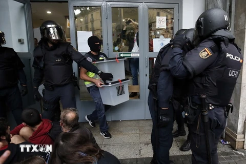 Cảnh sát Tây Ban nha tịch thu các hòm phiếu tại một điểm bỏ phiếu ở Barcelona ngày 1/10. (Nguồn: AFP/TTXVN)