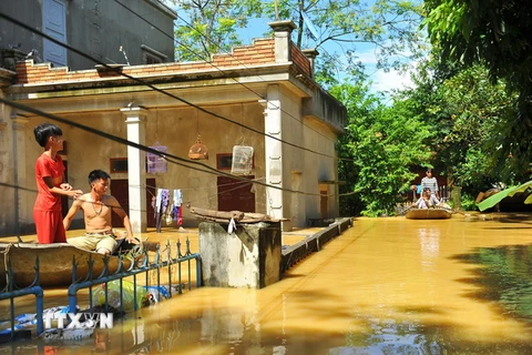 Nước ngập sâu nên người dân tại thôn Kiến Phong, xã Gia Tường, huyện Nho Quan, Ninh Bình phải di chuyển bằng thuyền. (Ảnh: Minh Đức/TTXVN)