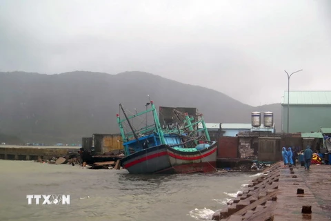 Một tàu cá của ngư dân Bình Định bị sóng đánh va kẹt vào kè đá tại Cảng cá Quy Nhơn. (Ảnh: Phạm Kha/TTXVN)