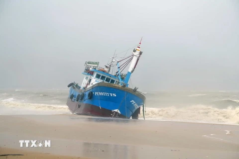 Tàu cá PY99777TS của ngư dân Phú Yên bị sóng đánh dạt vào bờ biển thành phố Quy Nhơn. (Ảnh: Phạm Kha/TTXVN)