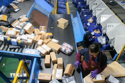 Nhân viên của Alibaba đóng gói hàng hóa trong ngày mua sắm khuyến mại trực tuyến "ngày Độc thân" 11/11 tại Thượng Hải. (Nguồn: THX/TTXVN)