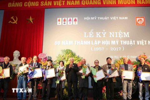 Đại diện Ban chấp hành Trung ương Hội mỹ thuật Việt Nam trao bằng khen cho các họa sỹ có thành tích xuất sắc góp phần xây dựng Hội mỹ thuật Việt Nam. (Ảnh: Thành Đạt/TTXVN)