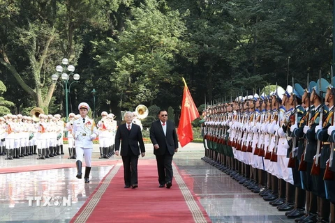 Tổng Bí thư Nguyễn Phú Trọng và Tổng Bí thư, Chủ tịch nước Lào Bounnhang Vorachith duyệt Đội danh dự Quân đội nhân dân Việt Nam tại Lễ đón. (Ảnh: Trí Dũng/TTXVN)