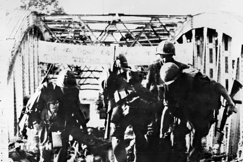 Trước sức tấn công vũ bão của quân và dân thành phố Huế đêm 31/1/1968, lính Mỹ khiêng xác đồng bọn rút chạy qua cầu Tràng Tiền. (Ảnh: Tư liệu TTXGP)