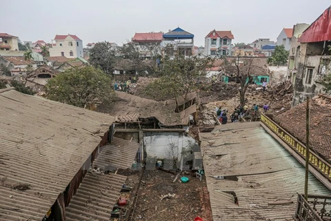 Những ngôi nhà nằm trong bán kính vụ nổ bị hư hại toàn bộ phủ một lớp bụi trắng xóa. (Ảnh: Minh Sơn/Vietnam+)