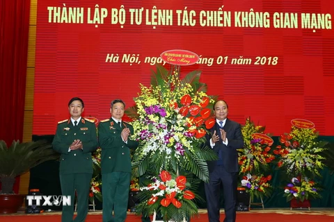 Thủ tướng Nguyễn Xuân Phúc tặng hoa chúc mừng Bộ Tư lệnh tác chiến Không gian mạng. (Ảnh: Thống Nhất/TTXVN)