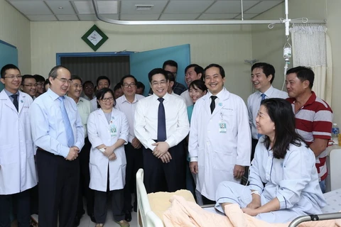 Bí thư Thành ủy TP. Hồ Chí Minh Nguyễn Thiện Nhân cùng các y bác sỹ đến thăm hỏi bệnh nhân đang điều trị nội trú tại Bệnh viện Đại học Y Dược. (Ảnh: Anh Tuấn/TTXVN)