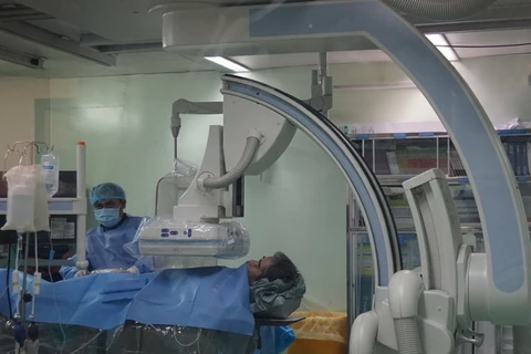 Bệnh nhân S được các bác sĩ áp dụng kỹ thuật chụp số hoá xoá nền điều trị trong phòng DSA với nhiều trang thiết bị hiện đại. (Ảnh: Thanh Sang/TTXVN)