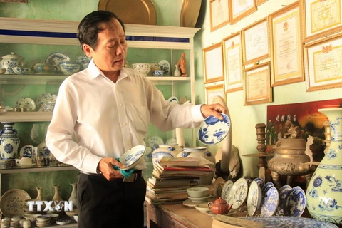 Thầy giáo Võ Thanh Phương với những cổ vật sưu tầm được. (Ảnh: Phước Ngọc/TTXVN)