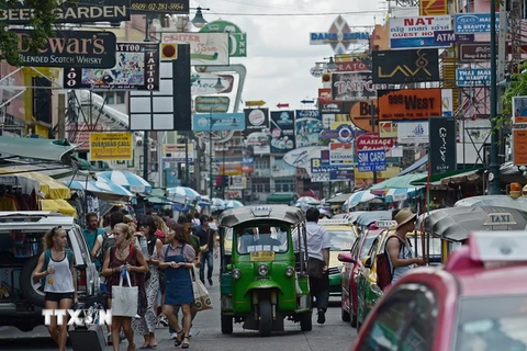 Khách du lịch dạo chơi trên một tuyến phố thương mại ở thủ đô Bangkok. (Nguồn: AFP/TTXVN)